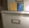 The blueprint's placement, peeking out of a filing cabinet
